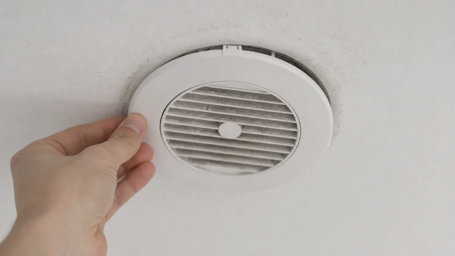 Bouche d'extraction de VMC encrassée démontée au plafond d'une salle de bain